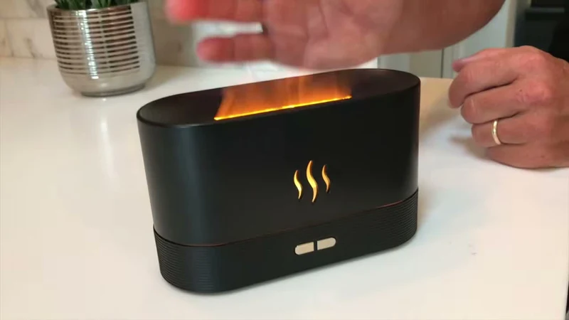 Umidificador oval preto com névoa iluminada no topo